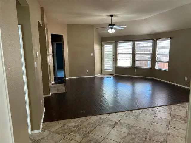 an empty room with floor to ceiling windows and chandelier