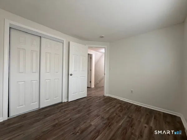 a view of an empty room with wooden floor