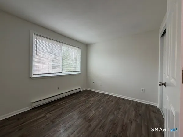 a view of a room with wooden floor and window