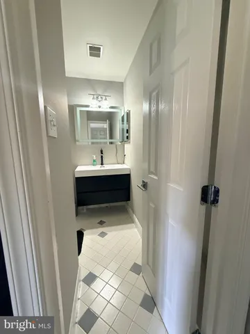 a bathroom with a sink and mirror with toilet