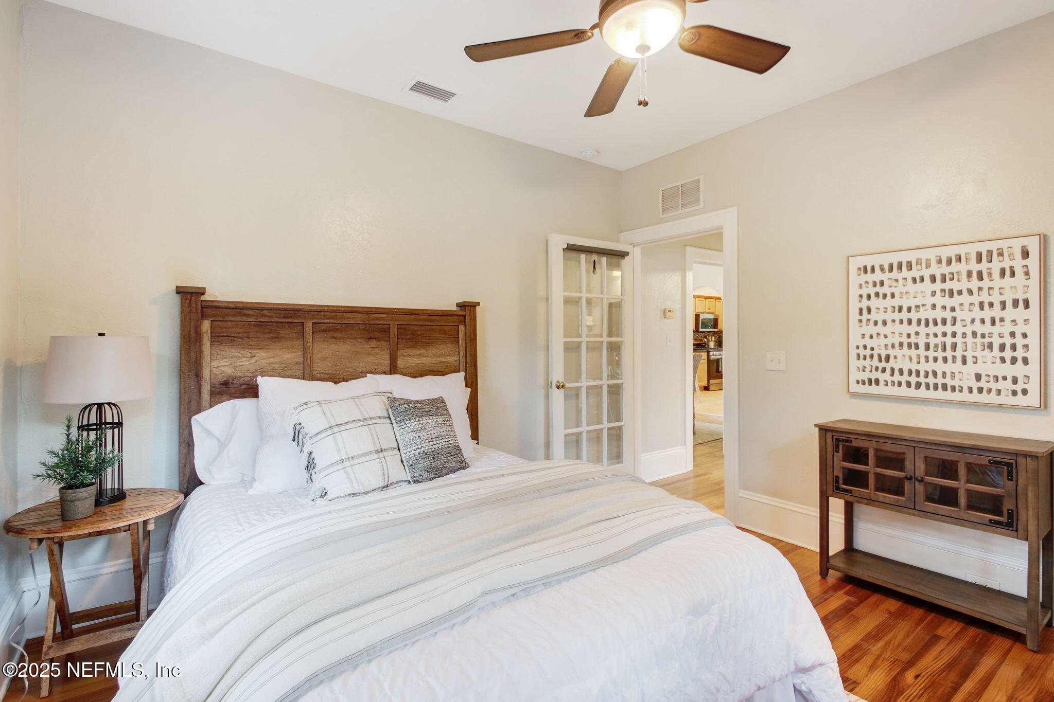 3515 Valencia Road Jacksonville, FL 32205 - Photo 15 of 24 a bedroom with a large bed and a chandelier