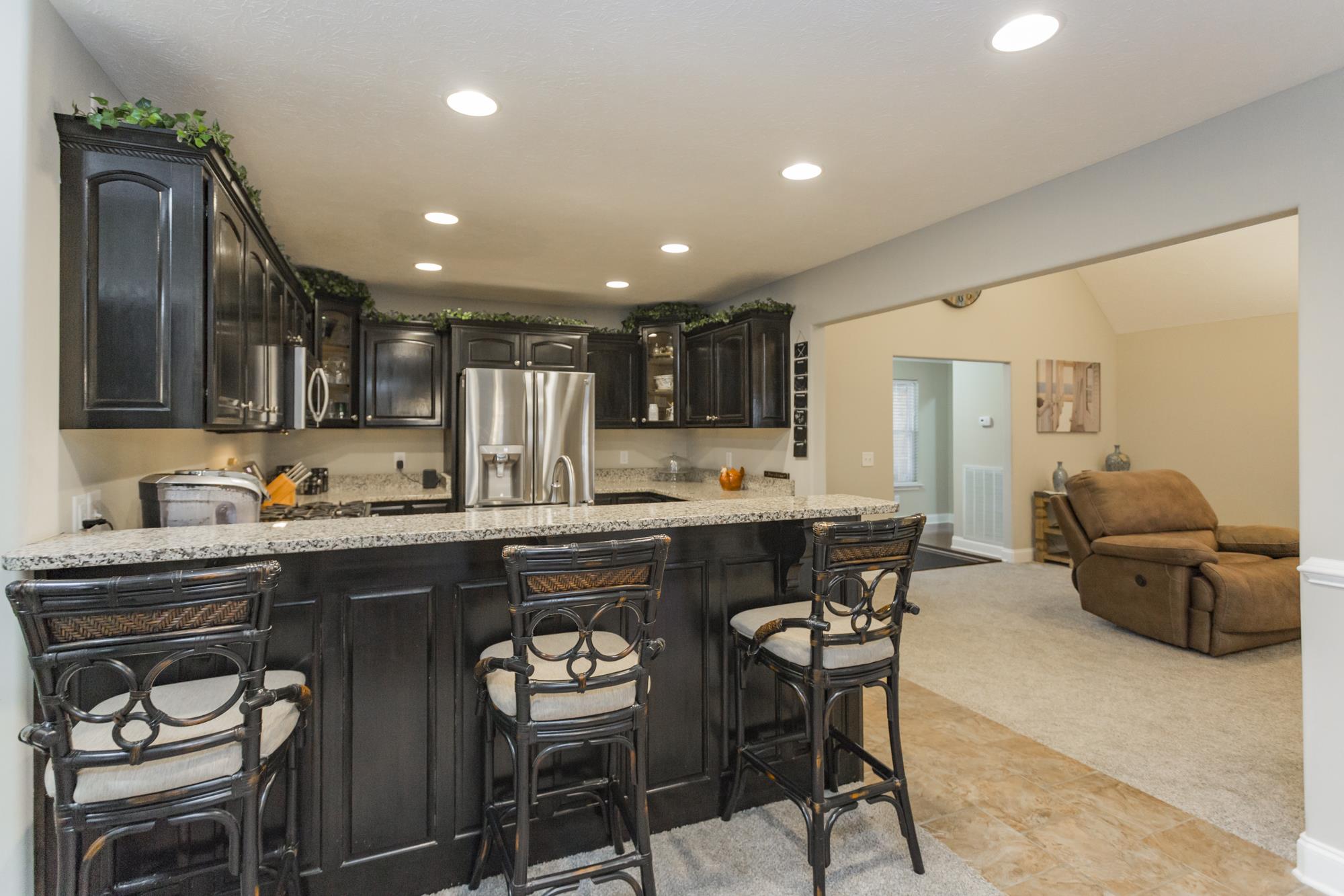484 Fowler Ford Road Portland, TN 37148 - Photo 12 of 29 a kitchen with stainless steel appliances granite countertop a table chairs sink refrigerator and cabinets