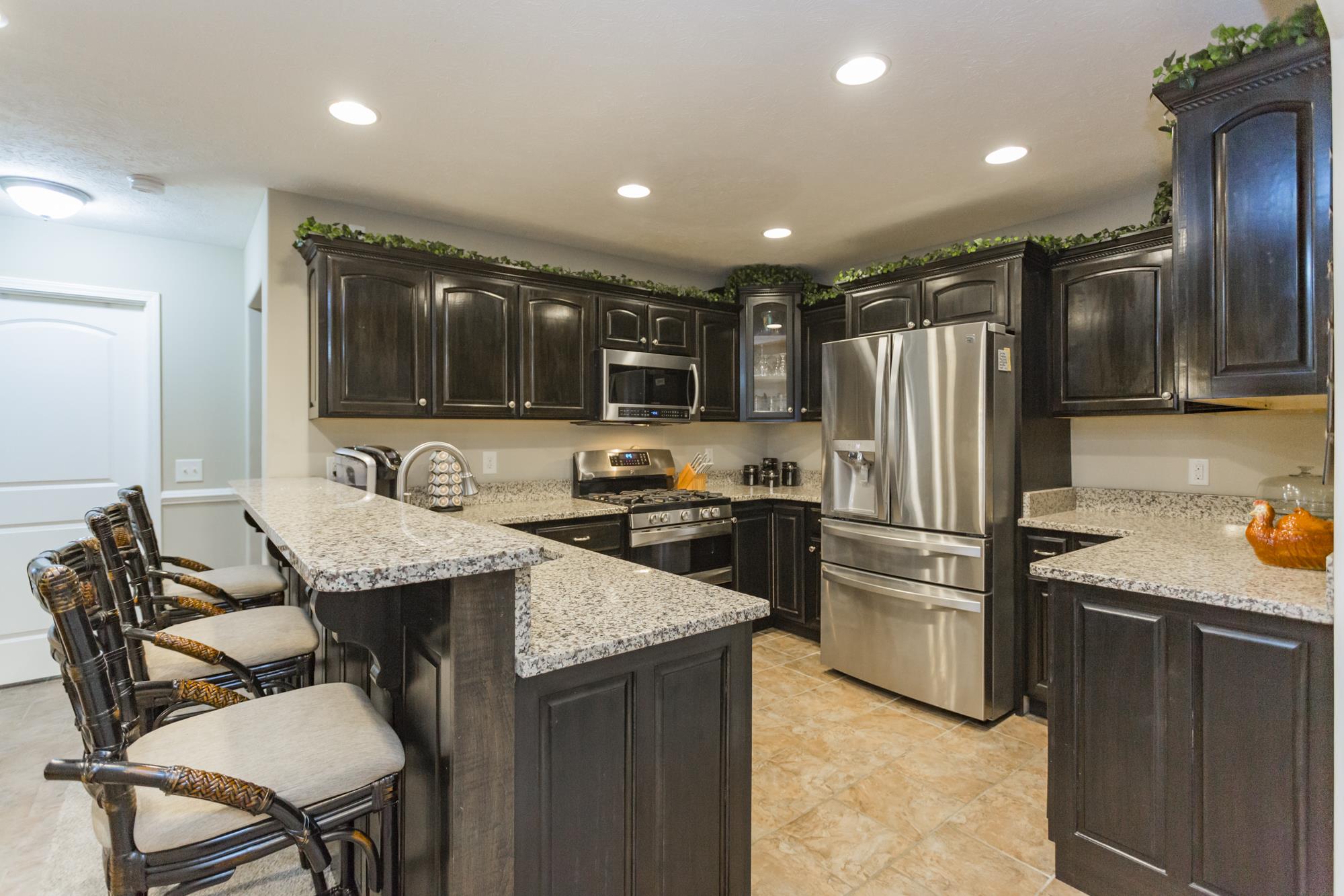 484 Fowler Ford Road Portland, TN 37148 - Photo 13 of 29 a kitchen with granite countertop kitchen island stainless steel appliances a refrigerator a sink and a stove