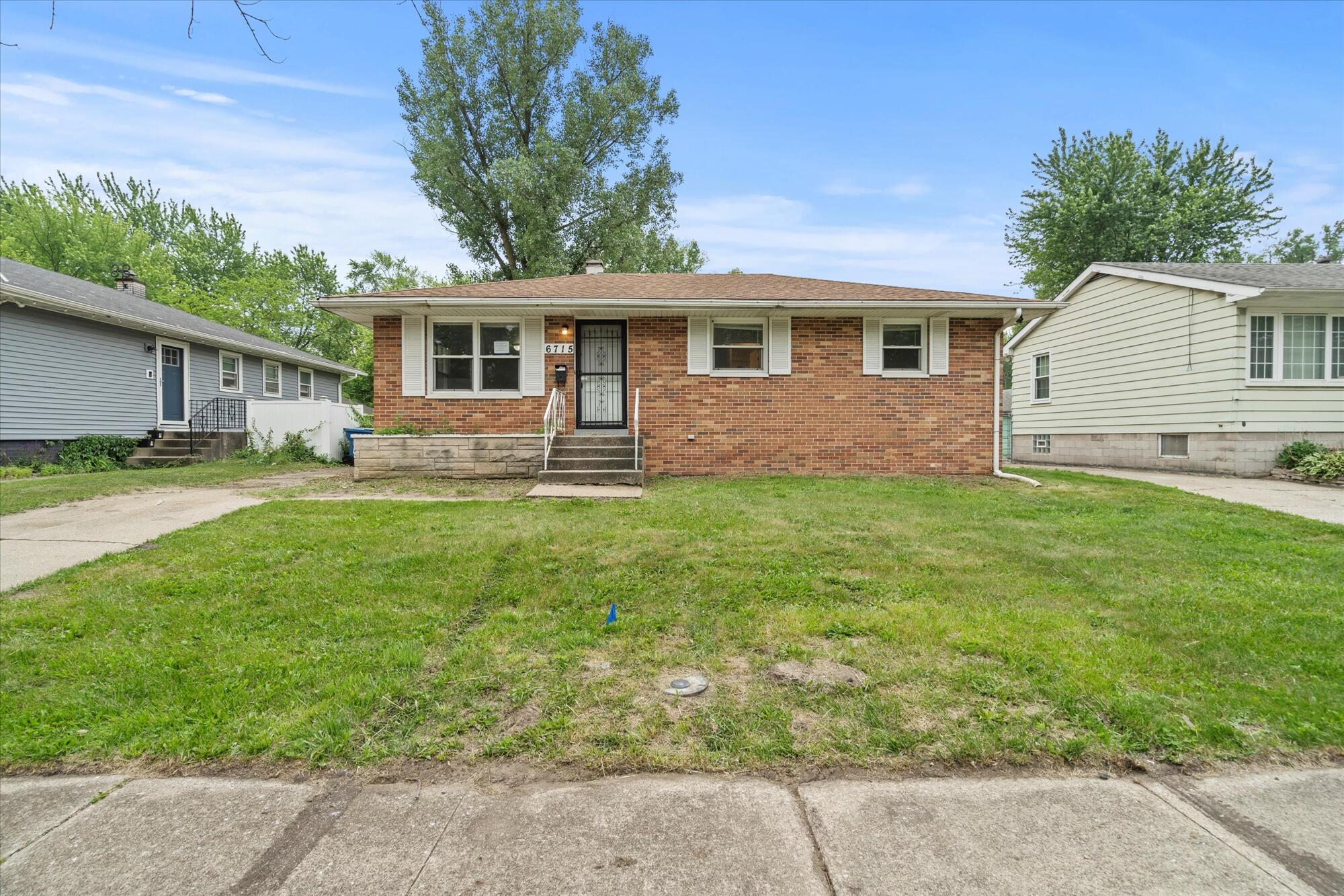 6715 East 3rd Avenue Gary, IN 46403 - Photo 14 of 25 a front view of a house with a yard and garage