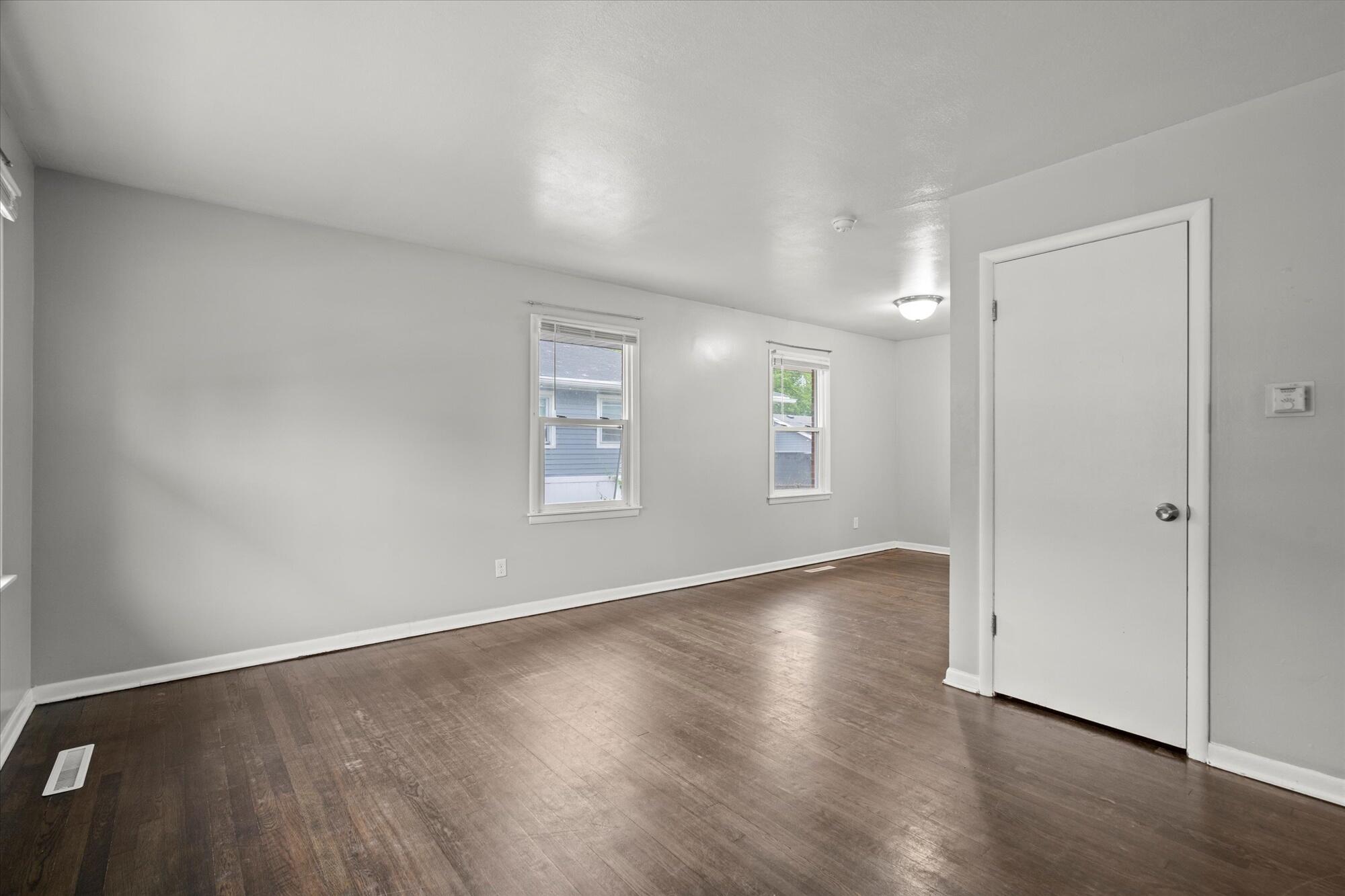 6715 East 3rd Avenue Gary, IN 46403 - Photo 15 of 25 an empty room with wooden floor cabinet and windows