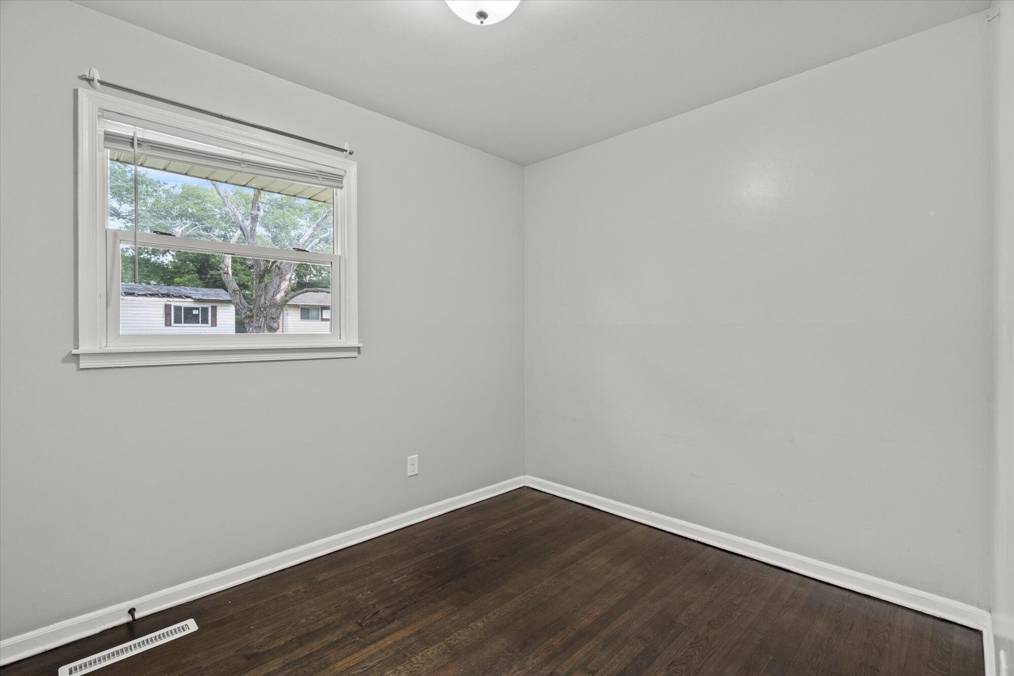 6715 East 3rd Avenue Gary, IN 46403 - Photo 20 of 25 a view of an empty room with wooden floor and a window