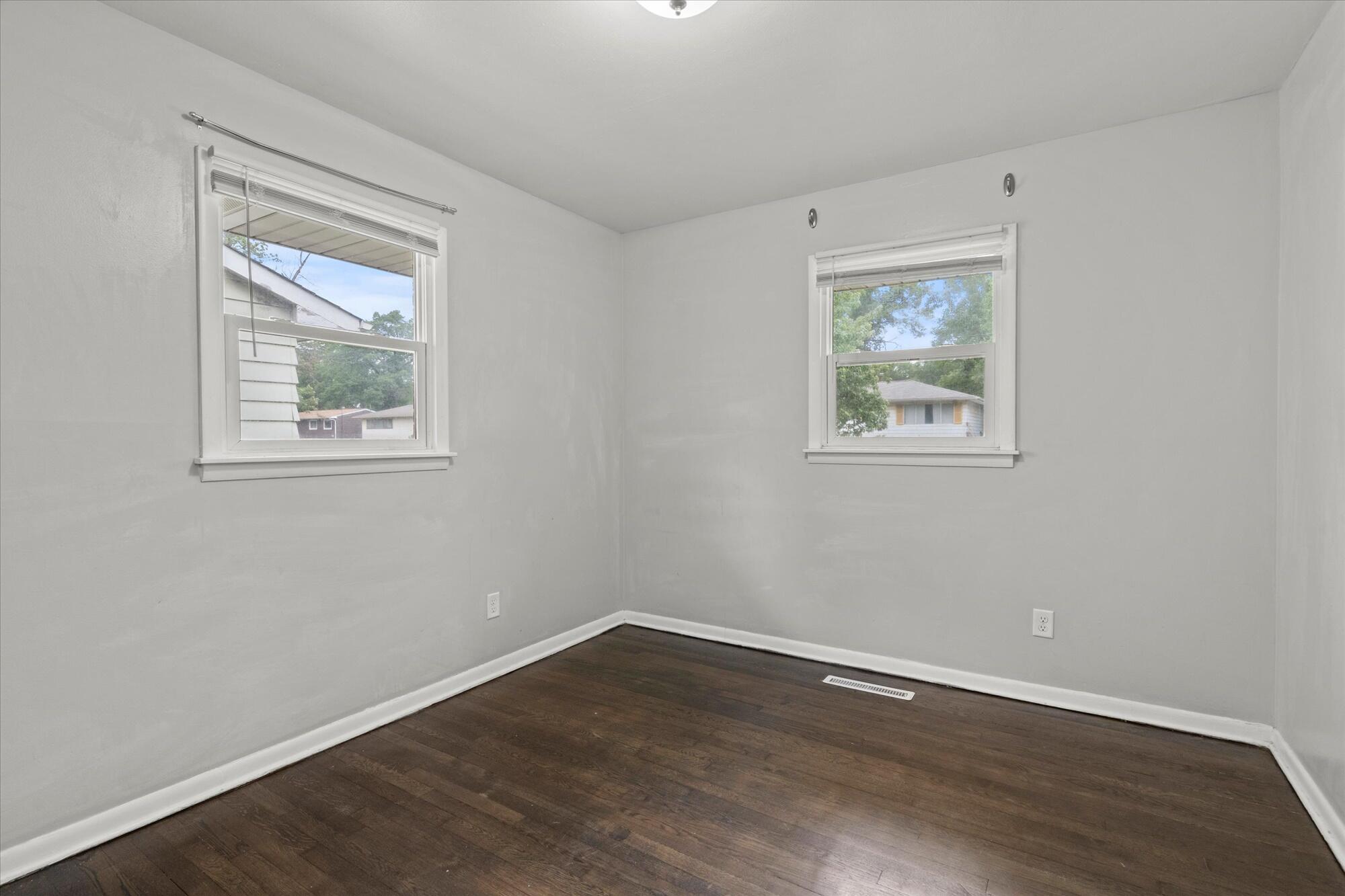 6715 East 3rd Avenue Gary, IN 46403 - Photo 23 of 25 a view of an empty room with wooden floor and a window
