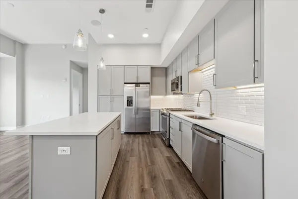 a kitchen with white cabinets appliances and sink