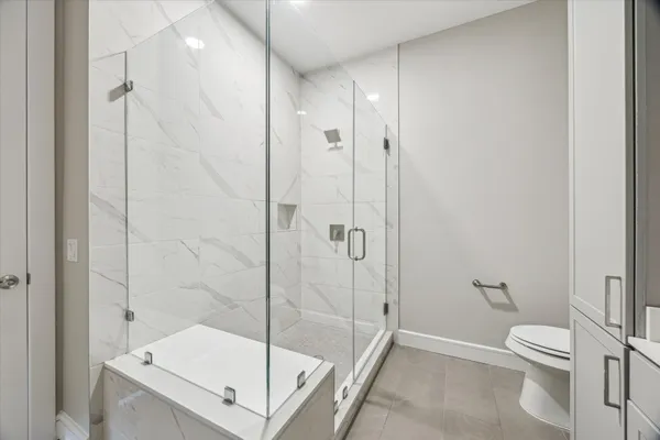 a bathroom with a shower a toilet and sink