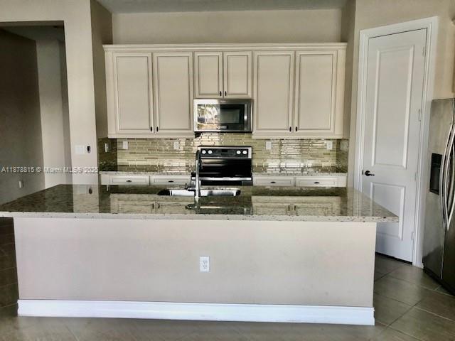 1415 Southwest 113th Avenue, Unit 1415 Pembroke Pines, FL 33025 - Photo 2 of 44 a view of kitchen with stainless steel appliances granite countertop a stove a refrigerator and a white cabinets