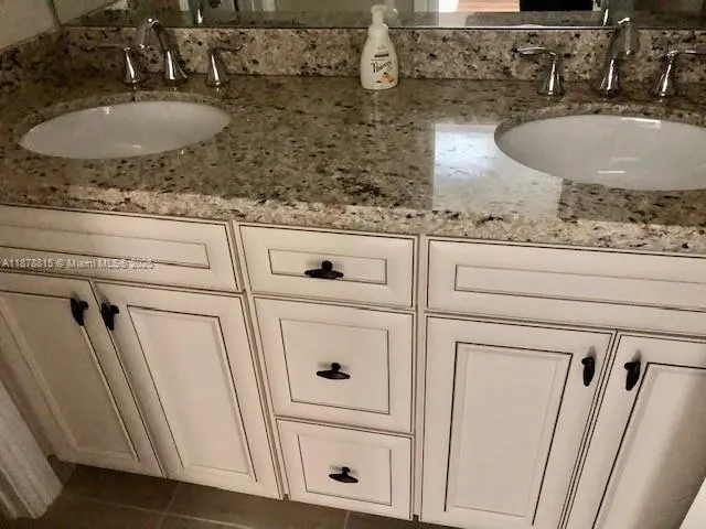 a bathroom with a granite countertop sink and mirror