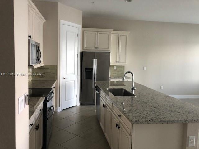 1415 Southwest 113th Avenue, Unit 1415 Pembroke Pines, FL 33025 - Photo 3 of 44 a kitchen with granite countertop a sink stove and refrigerator