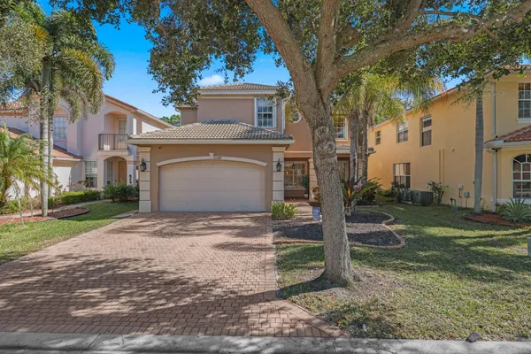 a view of a house with a yard and large tree