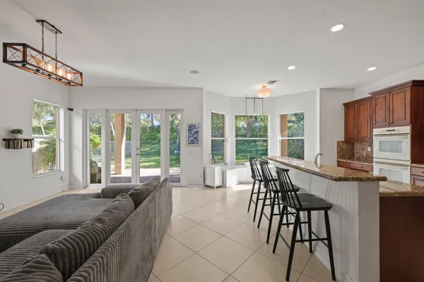a living room with furniture a flat screen tv and a large window