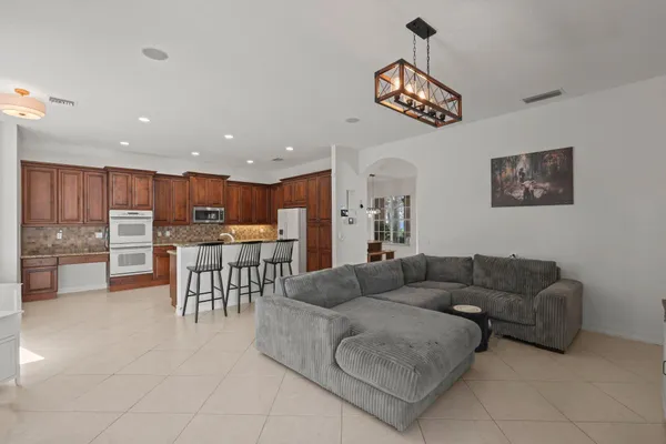 a kitchen with granite countertop a refrigerator and a stove top oven