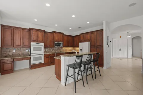 a kitchen with kitchen island wooden cabinets and refrigerator