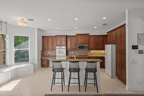 a kitchen with granite countertop sink table and chairs
