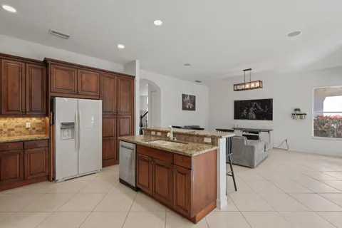 a kitchen with stainless steel appliances granite countertop a refrigerator and wooden cabinets