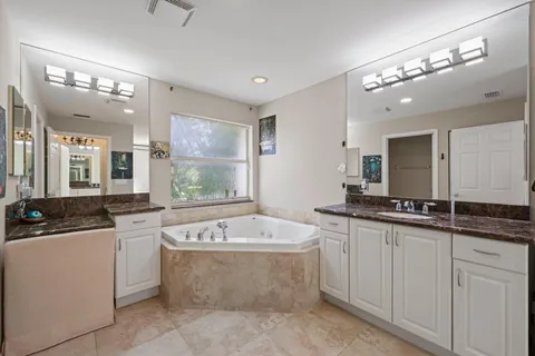a bathroom with a granite countertop sink a toilet and mirror