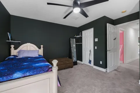 a bathroom with a granite countertop sink a toilet a mirror and shower