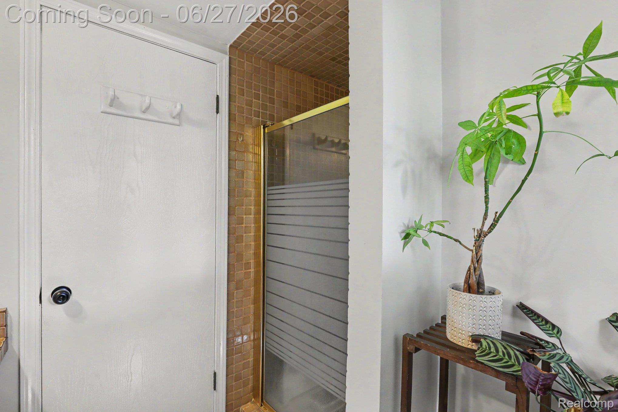 5134 Old Cove Road Clarkston, MI 48346 - Photo 13 of 27 Shower enclosure with gold-tone framing and frosted glass panels, surrounded by square mosaic wall tiles