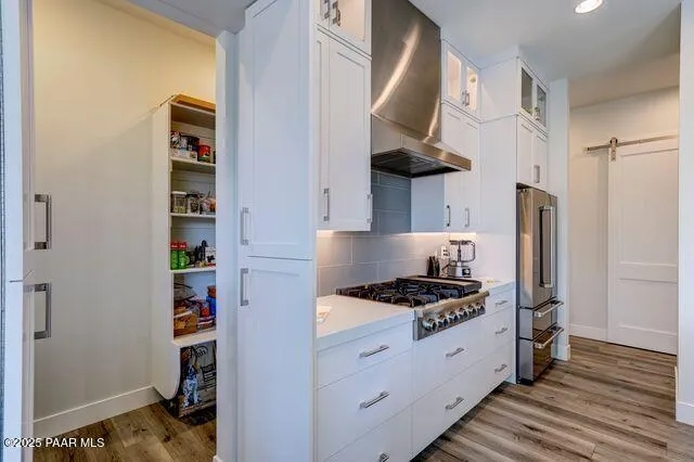 a kitchen with stainless steel appliances granite countertop a stove and a wooden floor
