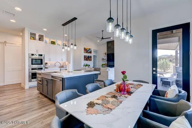 a living room with stainless steel appliances kitchen island granite countertop furniture and a dining table