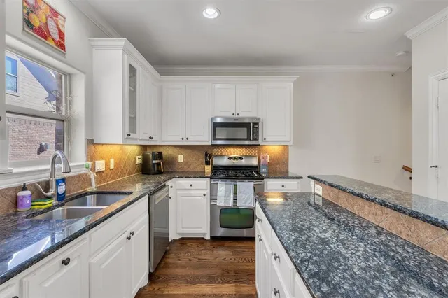 a kitchen with stainless steel appliances granite countertop a sink stove and refrigerator