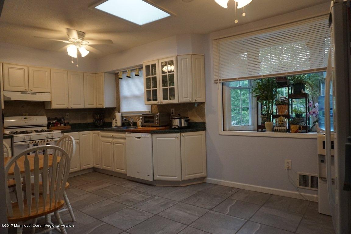 1093 Larsen Road Jackson, NJ 08527 - Photo 11 of 36 a kitchen with a refrigerator a stove top oven a sink and a large window