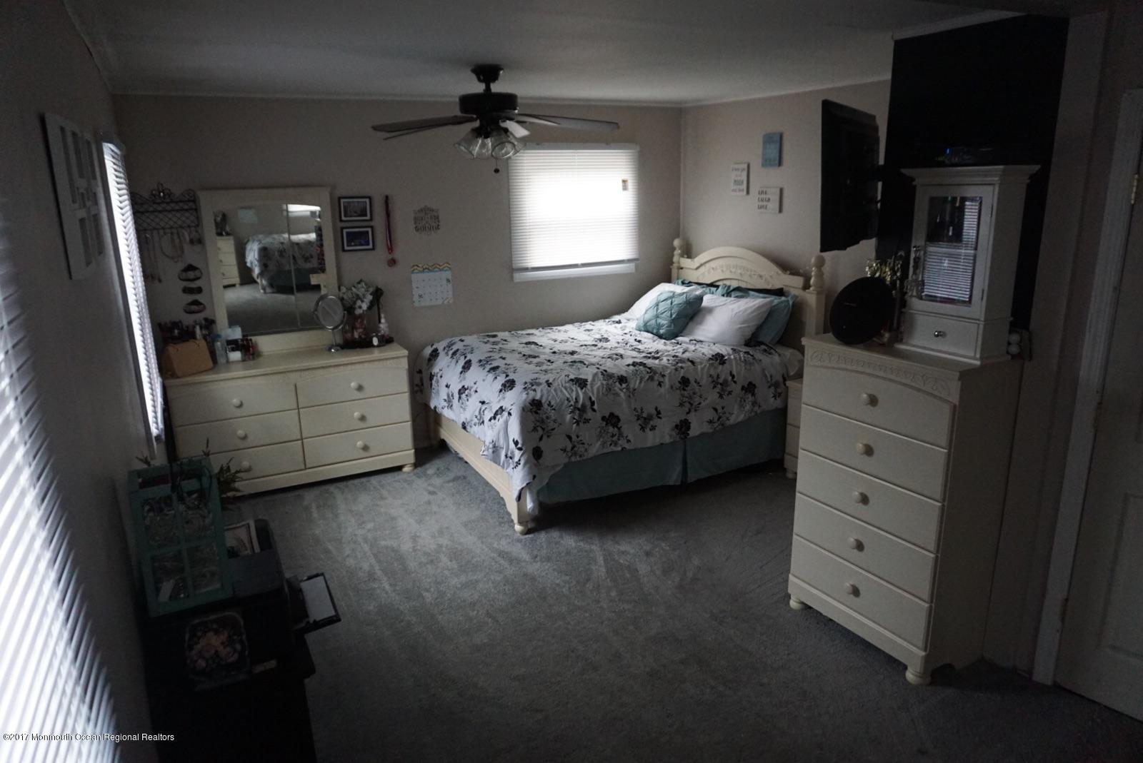 1093 Larsen Road Jackson, NJ 08527 - Photo 20 of 36 a bedroom with a bed a mirror on dresser and a window