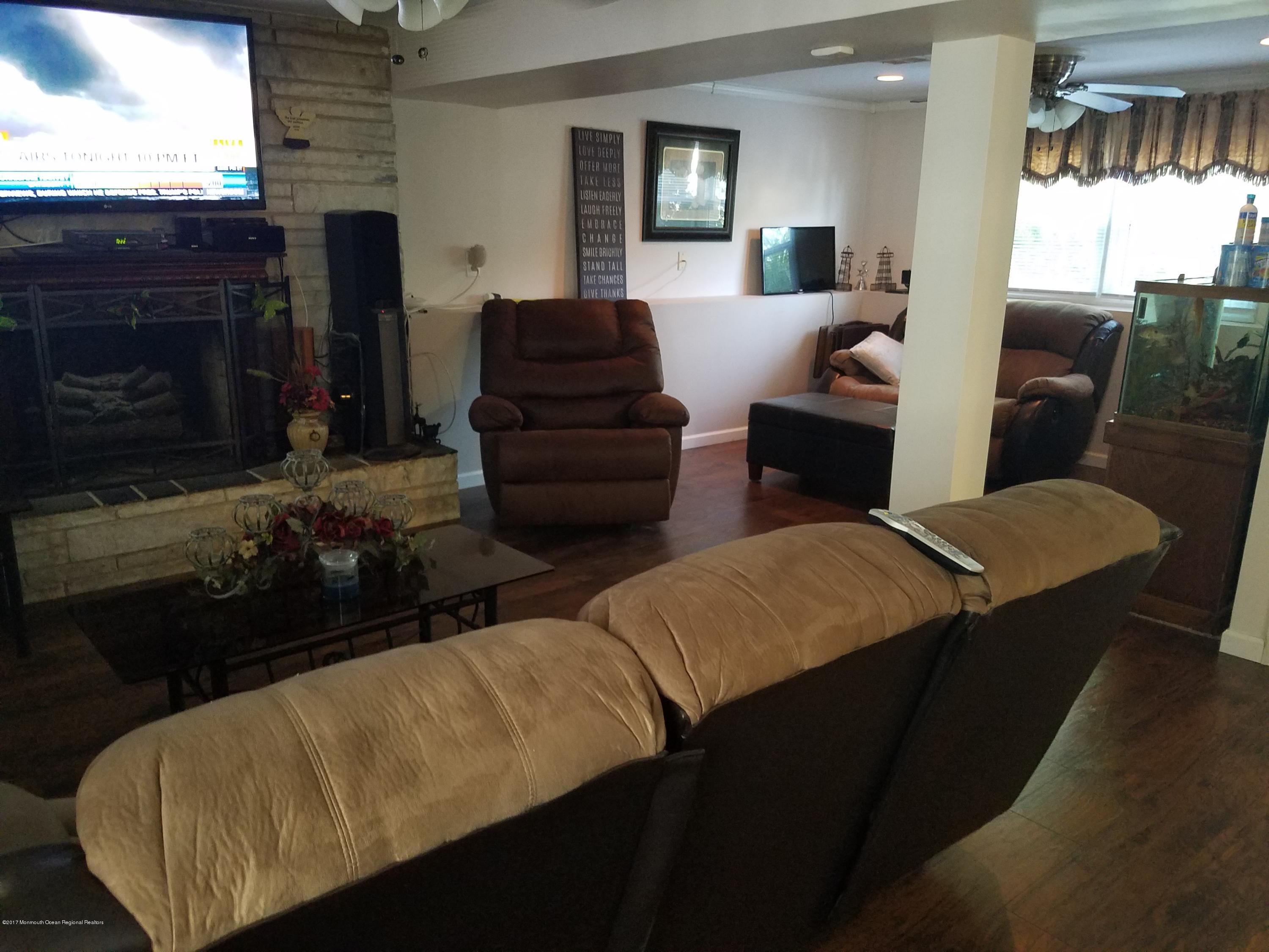 1093 Larsen Road Jackson, NJ 08527 - Photo 26 of 36 a living room with furniture a flat screen tv and a fireplace