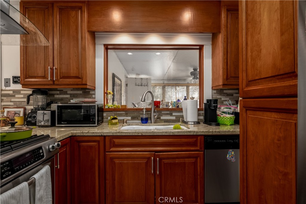 3642 Larchwood Place Riverside, CA 92506 - Photo 13 of 35 a kitchen with a sink and a stove with wooden floor