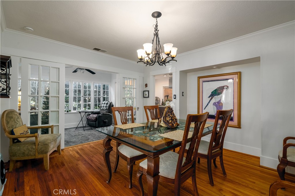 3642 Larchwood Place Riverside, CA 92506 - Photo 16 of 35 a view of a dining room with furniture wooden floor and chandelier