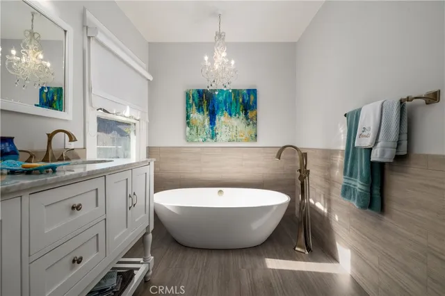 a spacious bathroom with a bathtub a sink and a chandelier