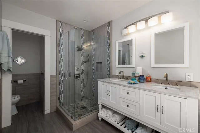 a bathroom with a double vanity sink mirror and shower