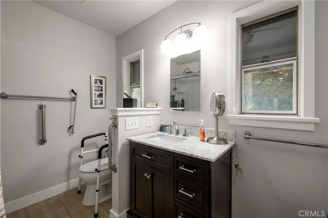 a bathroom with a granite countertop sink mirror and a toilet