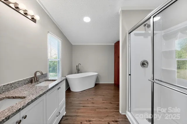 a bathroom with a granite countertop sink and mirror with bathtub
