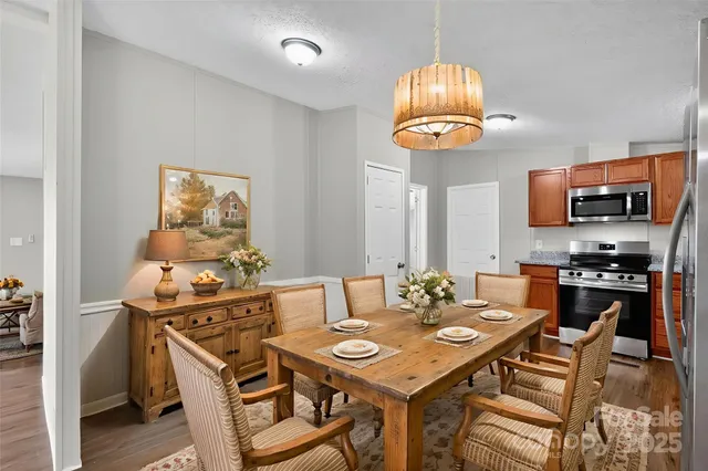 a view of a dining room with furniture a kitchen and chandelier