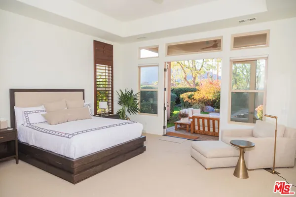 a bedroom with furniture and a large window