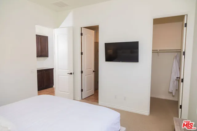 a large bed sitting in a bedroom next to a window