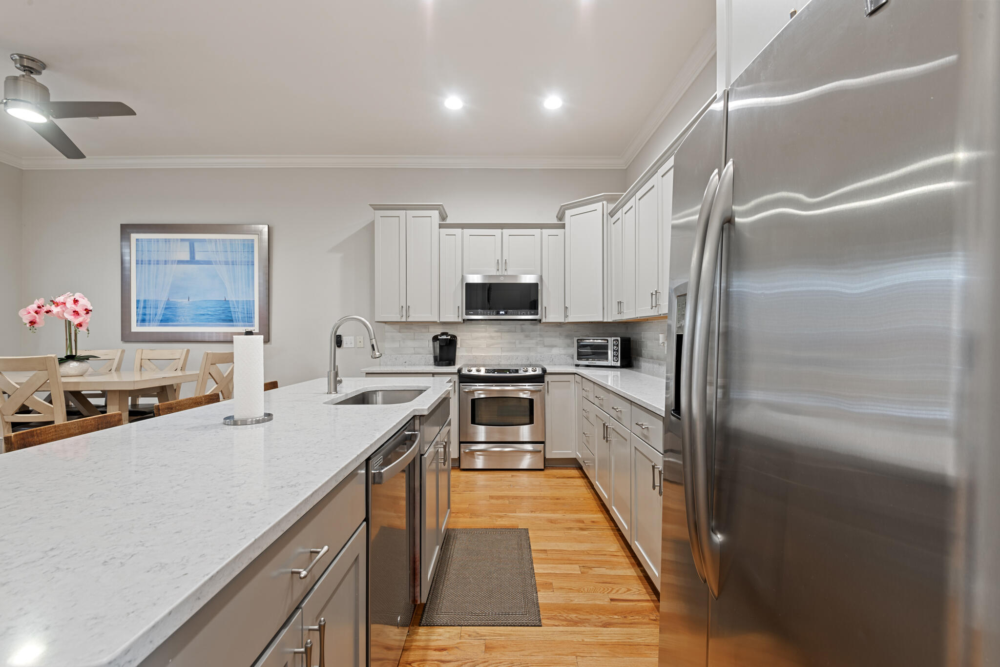 29 Coastal Grove Way, Unit 2 Santa Rosa Beach, FL 32459 - Photo 13 of 56 a kitchen with kitchen island a counter top space a sink stainless steel appliances and cabinets