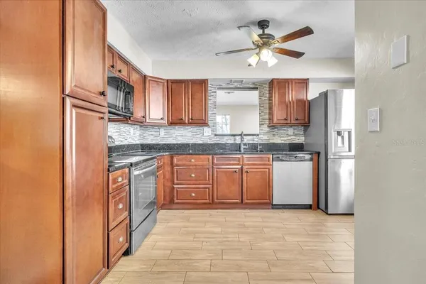 a kitchen with stainless steel appliances granite countertop a refrigerator and a sink