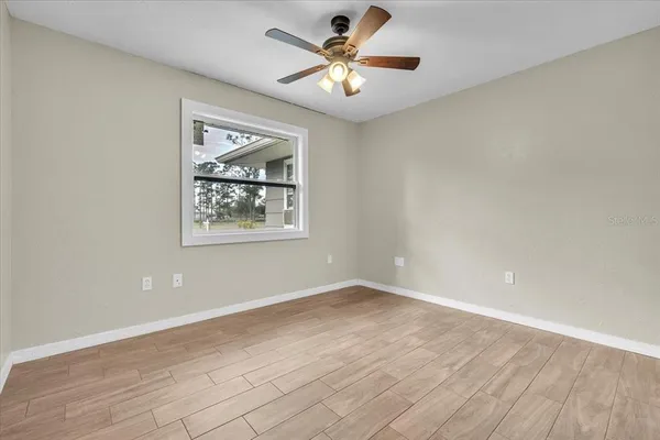 a view of an empty room with wooden floor