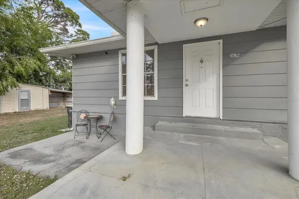 a view of a chair and table in backyard of the house