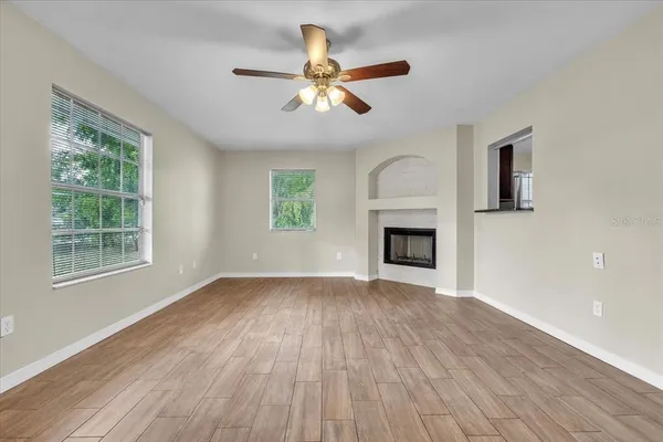 a view of an empty room with a window and fireplace