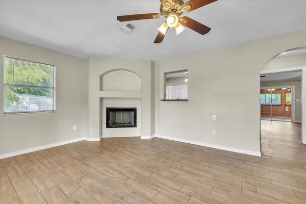 a view of an empty room with window and wooden floor