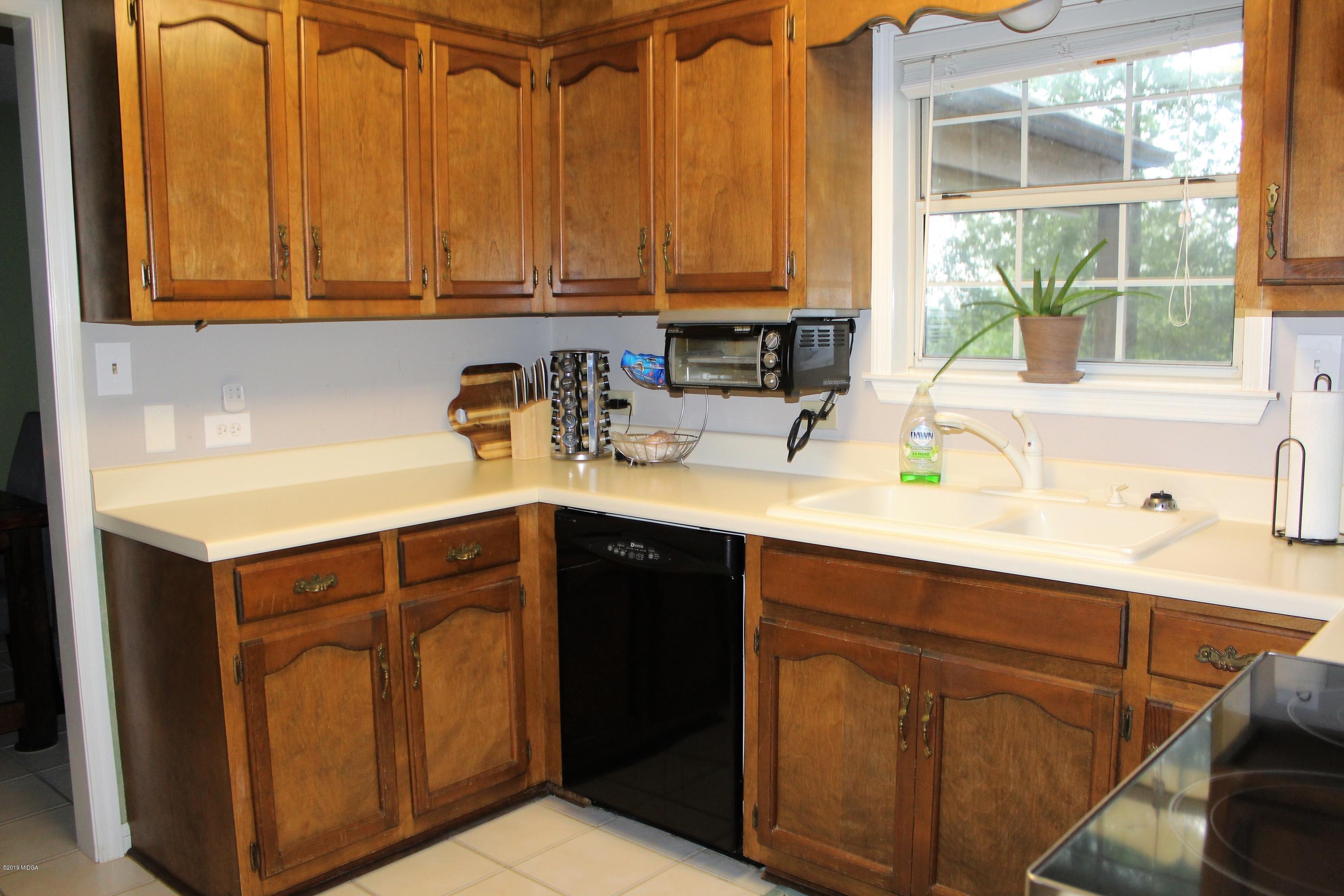 139 Bone Creek Road Macon, GA 31211 - Photo 6 of 18 a kitchen with stainless steel appliances granite countertop a sink a stove and a microwave