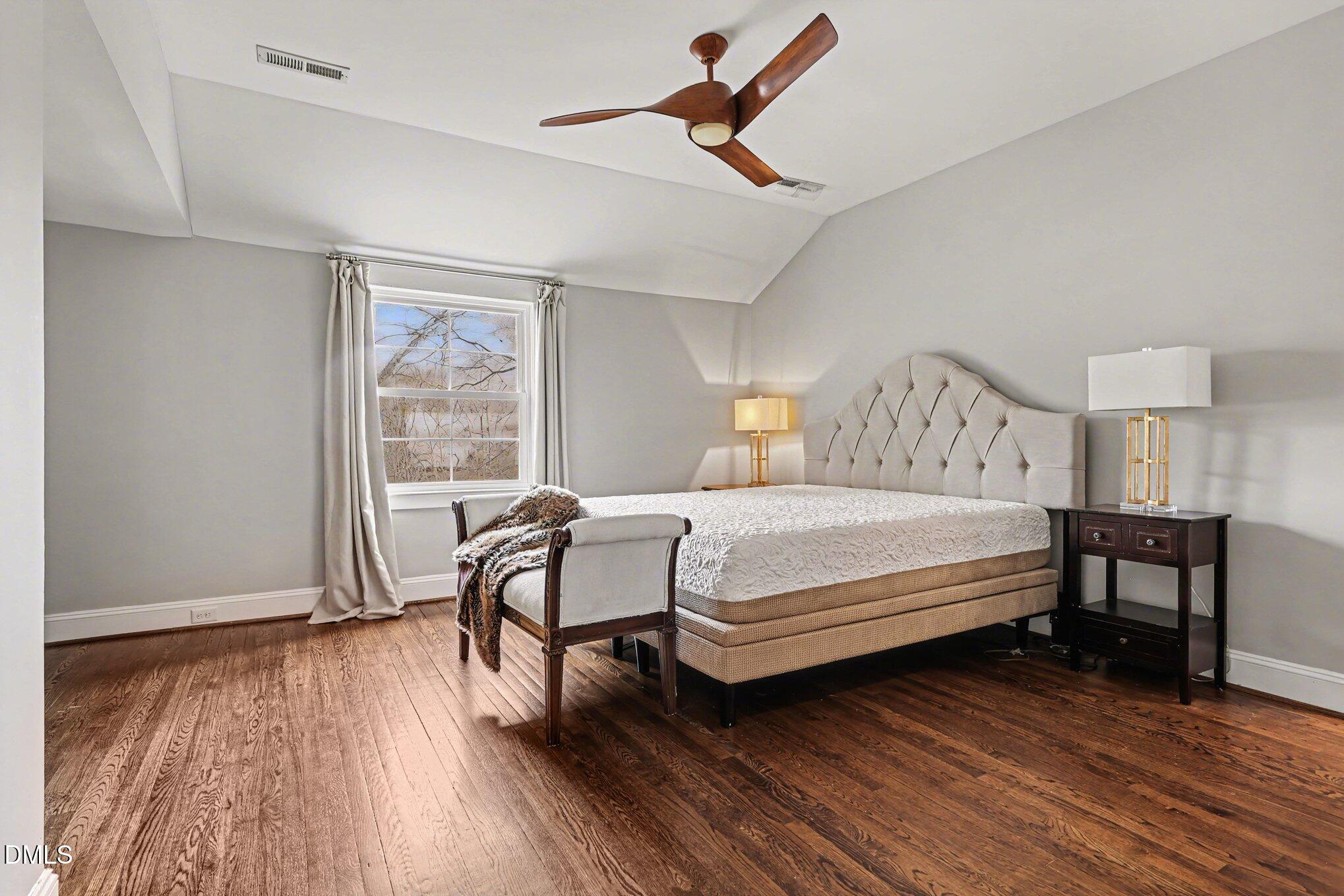 227 Furches Street Raleigh, NC 27607 - Photo 18 of 26 a bedroom with a bed a table and a large window