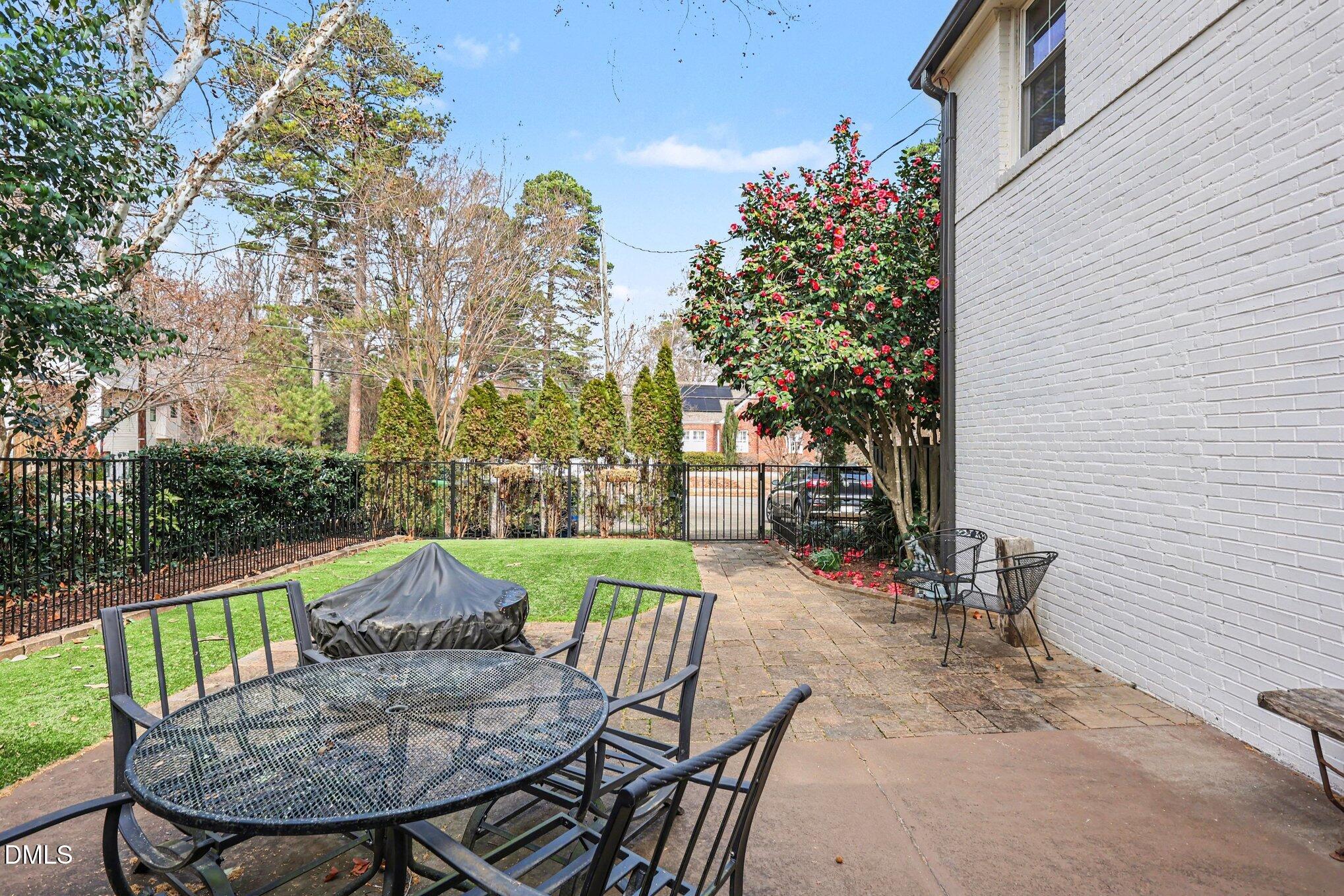 227 Furches Street Raleigh, NC 27607 - Photo 25 of 26 a view of a patio with table and chairs and potted plants with wooden fence