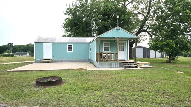 a view of a house with backyard and a tree